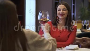 女士在餐馆里<strong>碰杯红酒</strong>。美丽的长发女孩在餐厅休息